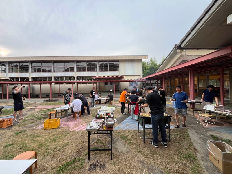 中庭に並ぶテーブルとBBQを楽しむ人たち